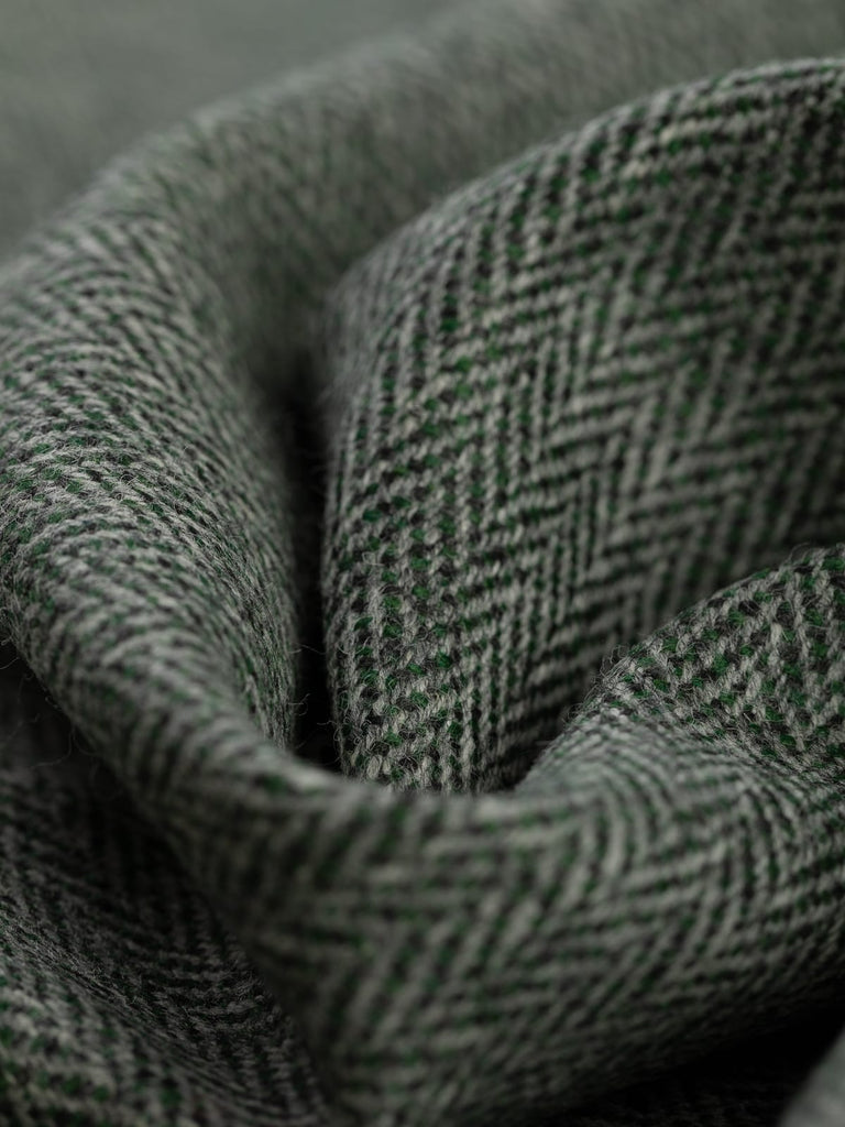 100% wool tweed pure wool fabric herringbone weave, forest green colours, woven with melange yarn, made in Huddersfield, made in Yorkshire. High quality twill weave wool fabric for clothing, jackets, dresses. buy fabric by the metre
