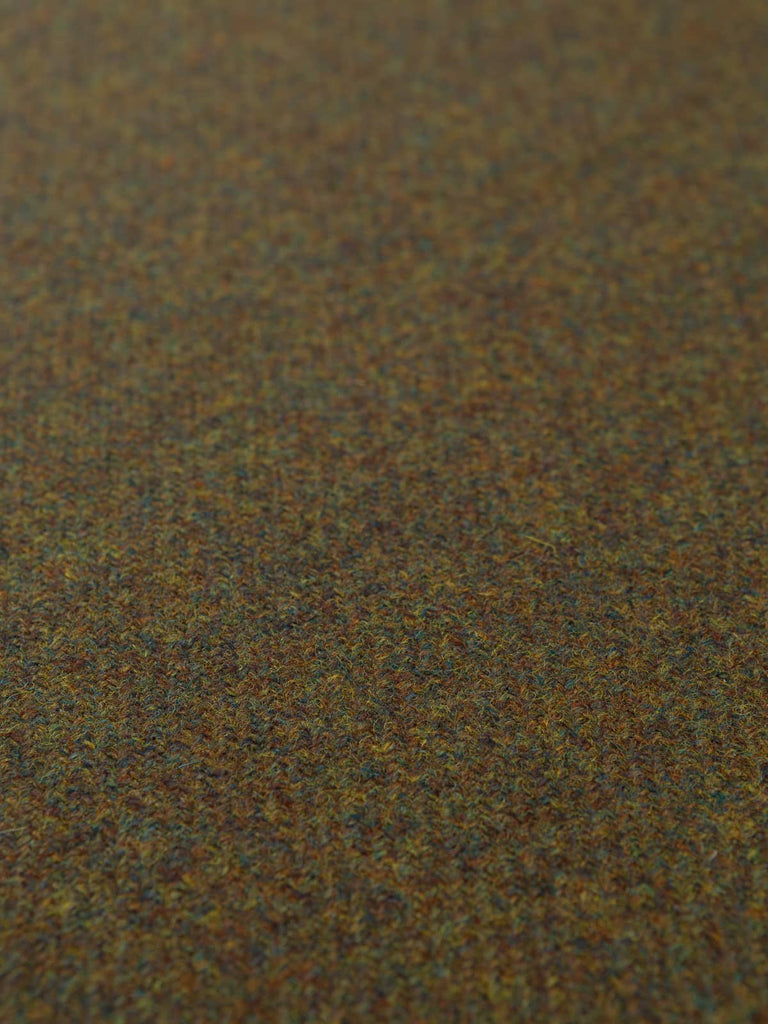 Flat angled shot of Verdant Vale Tweed highlighting the heritage twill pattern and natural mix of brown, green, and teal tones across the pure wool surface.