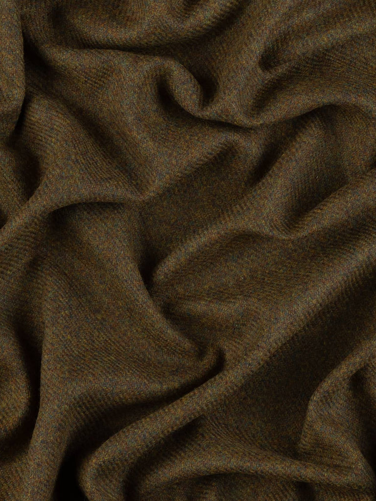 Aerial twist shot of Verdant Vale Tweed revealing its rustic-refined twill structure and the harmonious earthy palette of browns, greens, and teals.