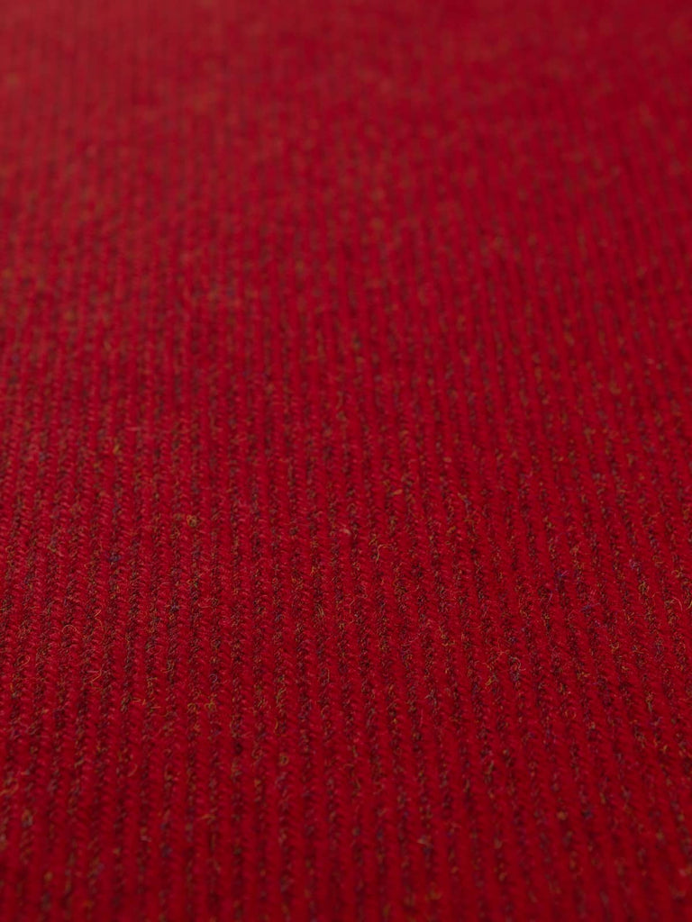 Flat angled shot of the Crimson Vale wool tweed highlighting its deep red melange yarns, hints of gold and blue, and structured twill weave with warm autumnal depth.