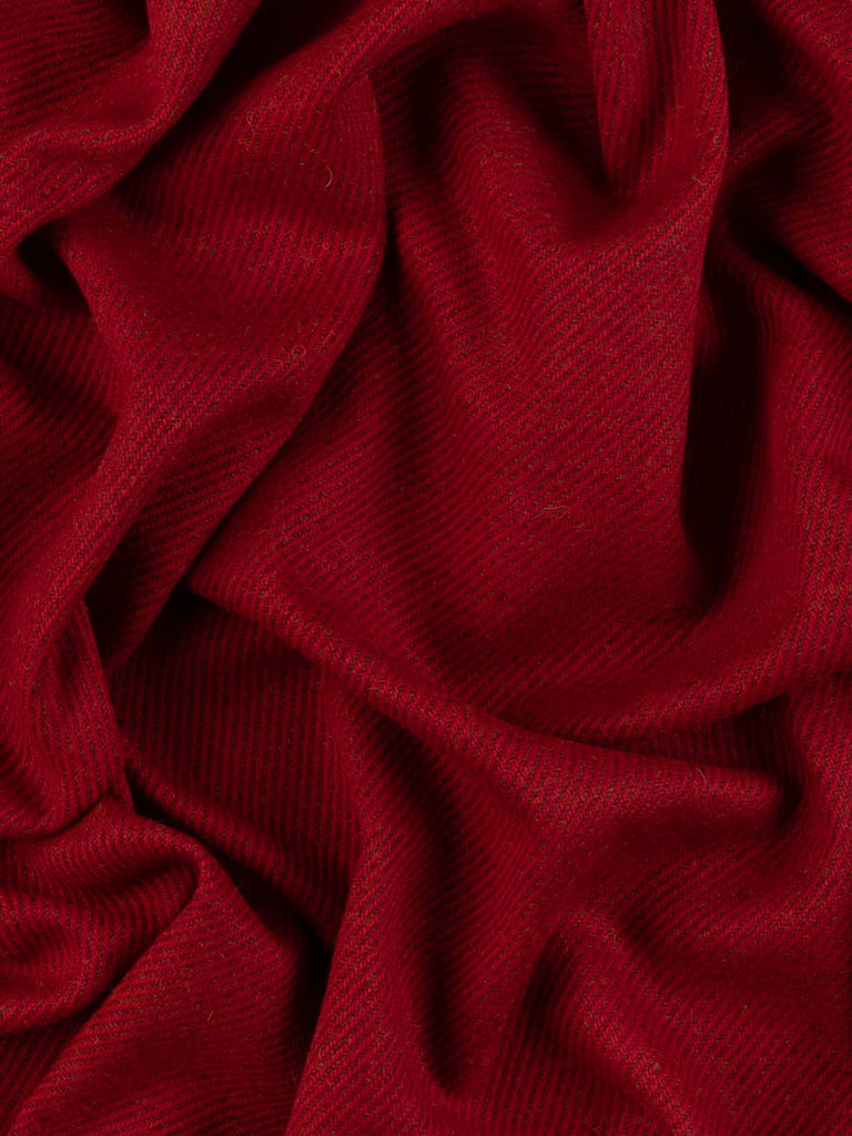 Aerial twist shot of the Crimson Vale fabric revealing its layered crimson and berry hues, golden flecks, and timeless twill weave with a warm, full-bodied finish.