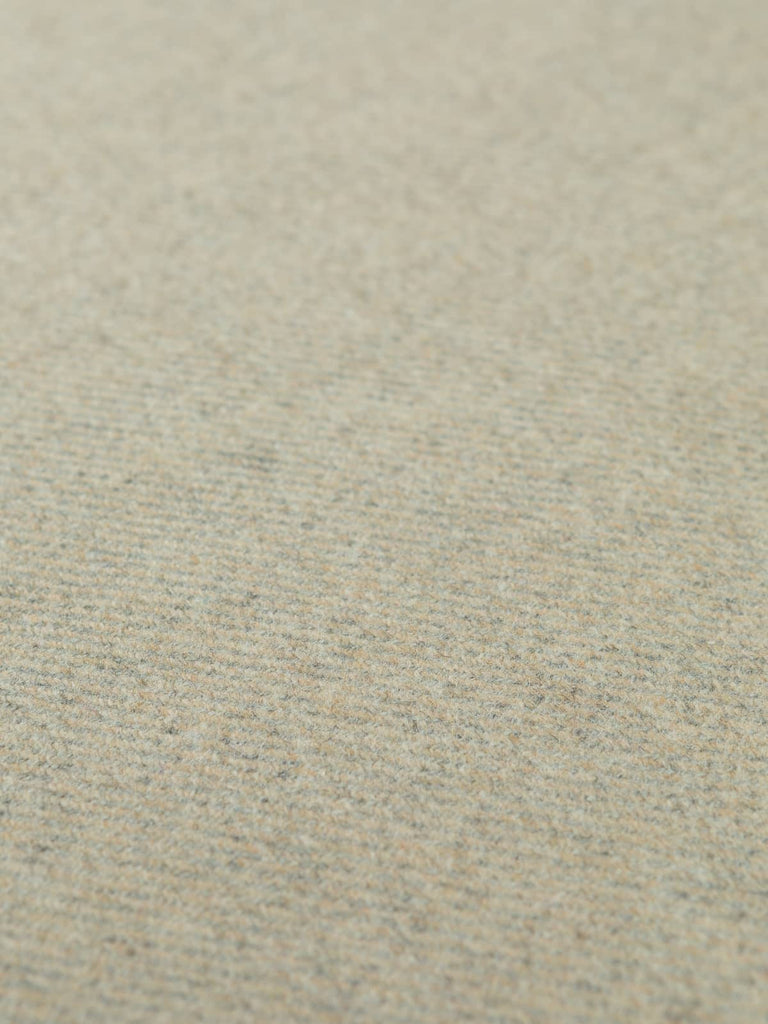 Flat angled shot of the Crimson Vale heavyweight wool tweed highlighting its warm red melange tones, festive undertones, and classic cavalry-style twill weave.