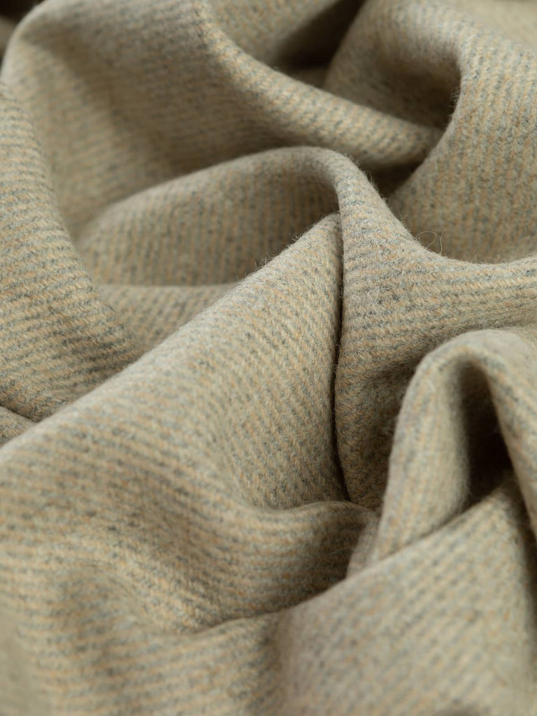 Angled twist shot of Heavy Crimson Vale tweed showing its deep crimson, garnet, and berry mélange with subtle gold and blue fibres and a rich twill texture.