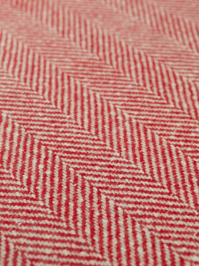 Flat angled shot of the jumbo herringbone fabric highlighting the striking red and natural white contrast and the oversized chevron pattern in chunky lambswool.