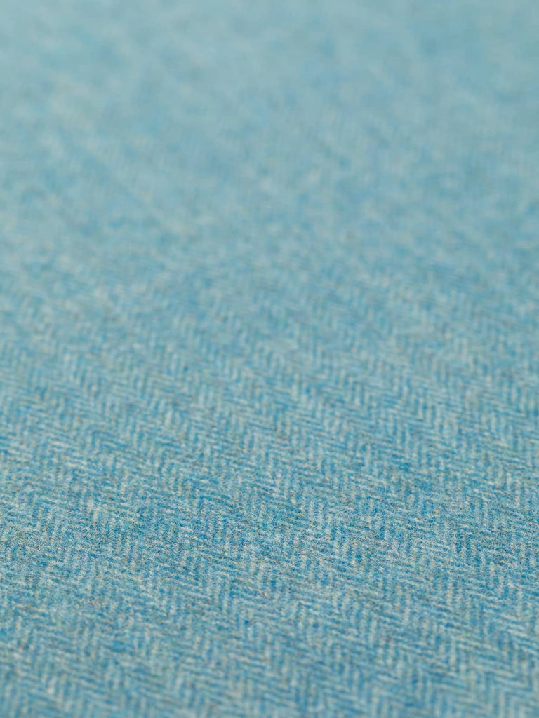 A detailed flat view of the Waterside 2 fabric, showcasing its classic herringbone pattern in a harmonious mix of frosty grey-green and vibrant blue-based turquoise. The close-up captures the fabric’s medium weight and soft texture, reflecting the serene yet dynamic qualities of waterside landscapes, perfect for elegant and timeless garment creations.