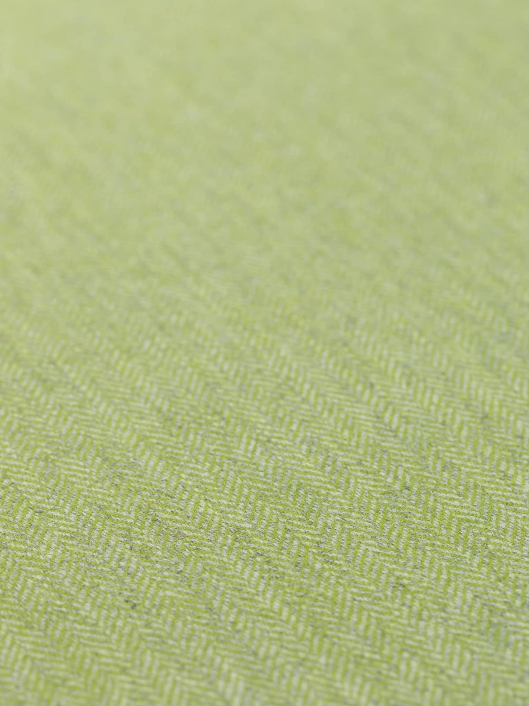 A detailed flat view of the Spring Fling fabric, capturing the bright lime green and subtle grey hues that define its cheerful herringbone pattern. The image emphasizes the fabric’s medium weight and the soft, natural texture of the wool, perfect for creating standout garments and accessories that celebrate the freshness of spring.