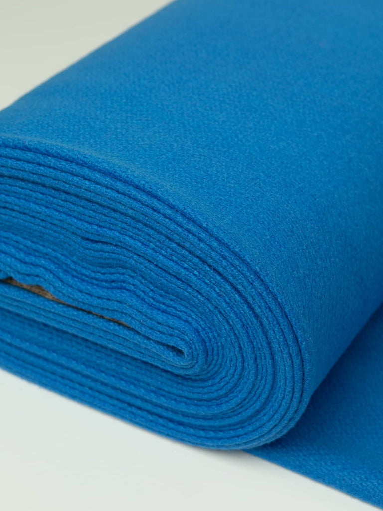 Angled roll of Cobalt Blue Twill Melton wool, 600gsm, in vivid sapphire hue with dense felted finish and smooth brushed surface