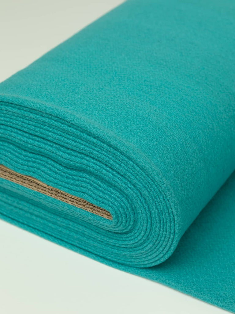 Angled roll of Teal Twist Twill Melton wool, 600gsm, in rich teal-turquoise blend with dense felted finish and smooth brushed texture