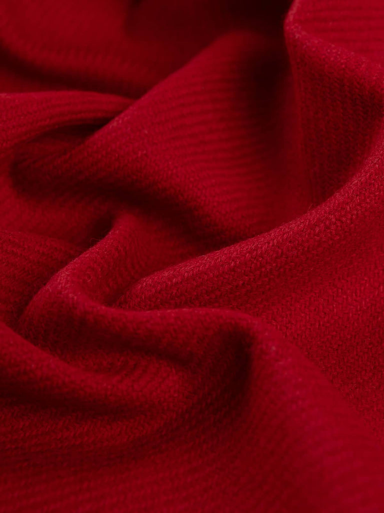 Angled twist shot of Winter Hearth tweed showing its rich holly-berry red yarns, subtle blue undertones, and the classic tweedy twill texture.