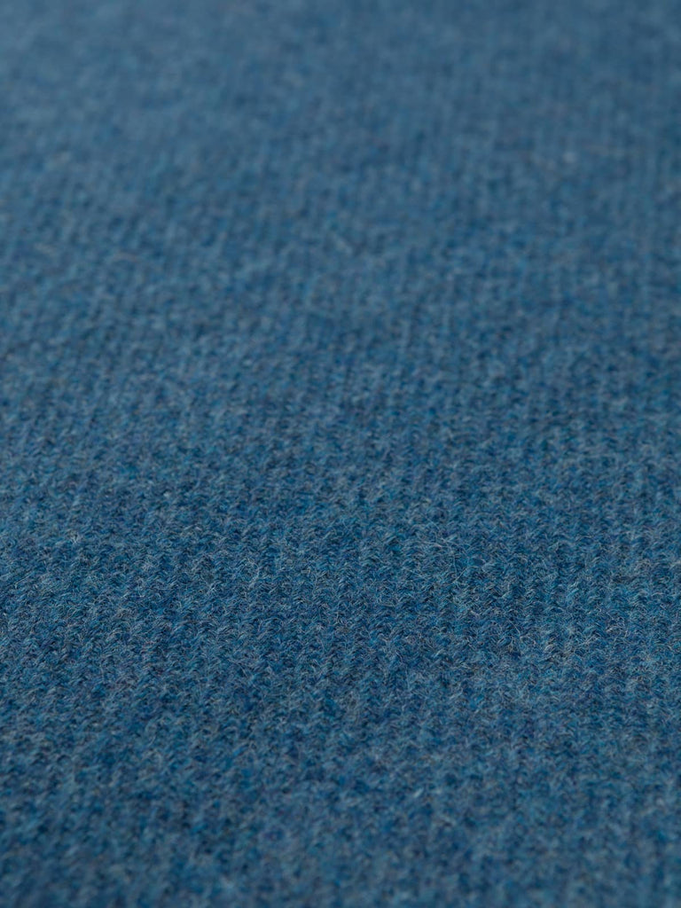 Flat angled shot of Blue Haven tweed displaying its fluid blue gradient, nuanced mélange yarns, and classic heritage tweedy twill texture.