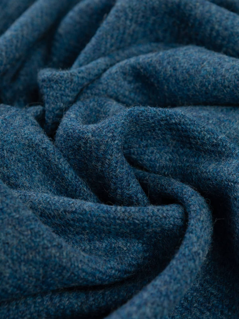 Angled twist shot of Blue Haven tweed showing its heritage tweedy twill, gradient blue melange base, and subtly dimensional, misty-grey to royal-blue tones.