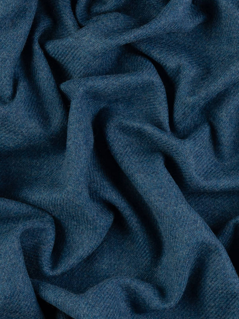 Aerial twist shot of Blue Haven wool tweed highlighting its shifting blue melange, tactile twill structure, and softly layered tonal depth.