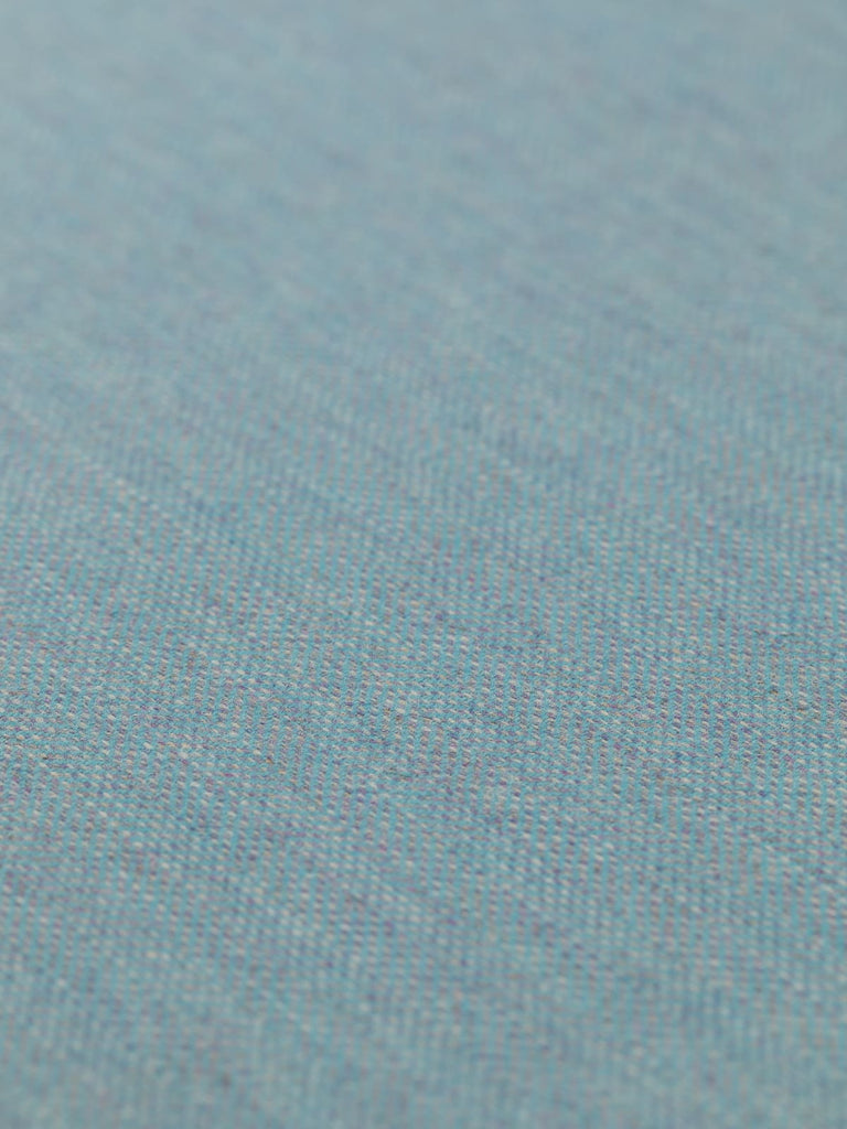 Angled detailed close-up of Eco Herringbone Yorkshire Tweed in Frosted Valley, showcasing the flat weave and subtle sheen. The cool aqua and lilac tones blend harmoniously, emphasizing the fabric’s unique herringbone pattern.