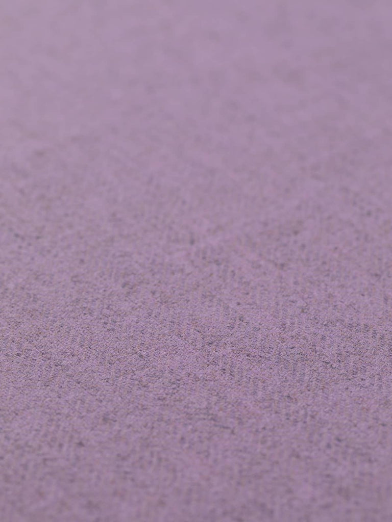 Angled flat view of Autumn Lilac lightweight lambswool herringbone fabric, 290gsm, displaying gentle lavender tones inspired by misty heather hills and twilight skies, with subtle grey melange texture