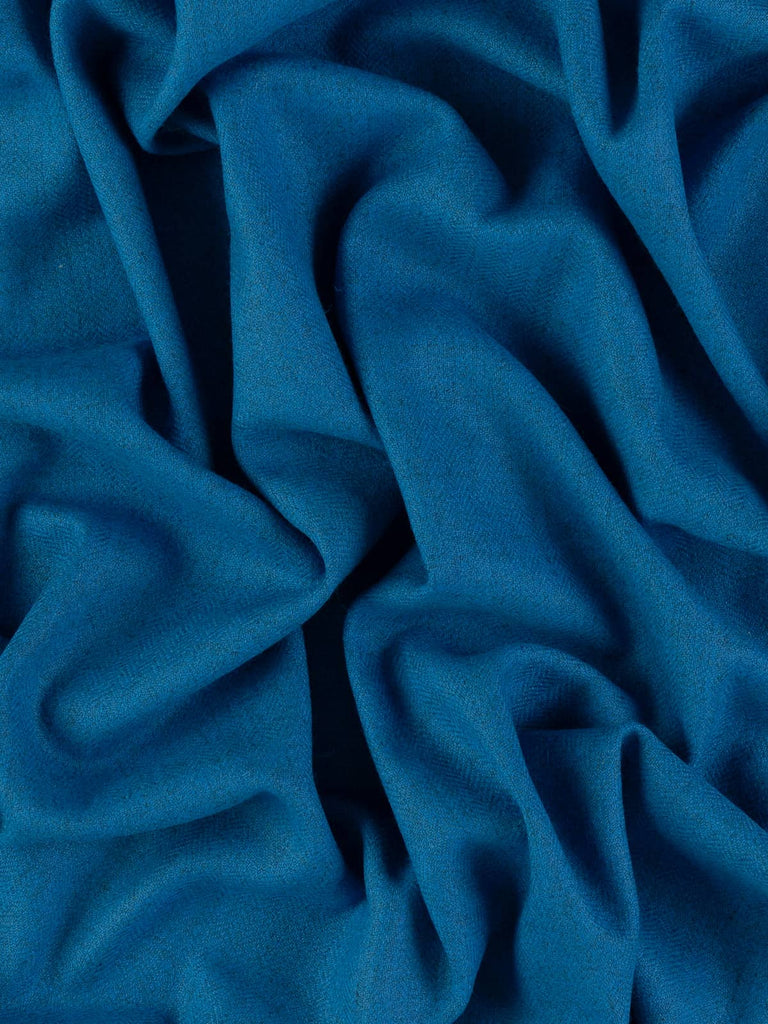 Overhead flat shot of Autumn Azure Yorkshire lambswool herringbone, revealing rhythmic chevron pattern in vivid azure and marled grey, smooth lightweight handle with elegant tailored drape