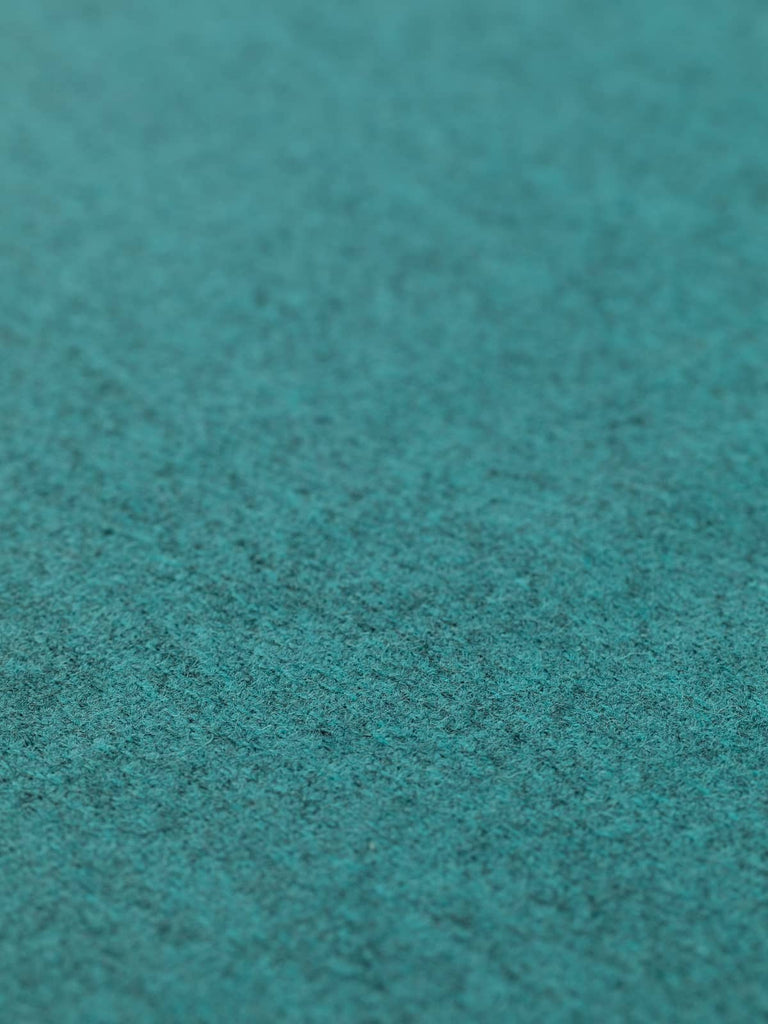 Angled flat view of Tealstone medium-weight wool tweed, 152cm wide, highlighting rich blue-green tones over a stone-grey melange base, with a refined herringbone texture and lightly brushed woollen surface