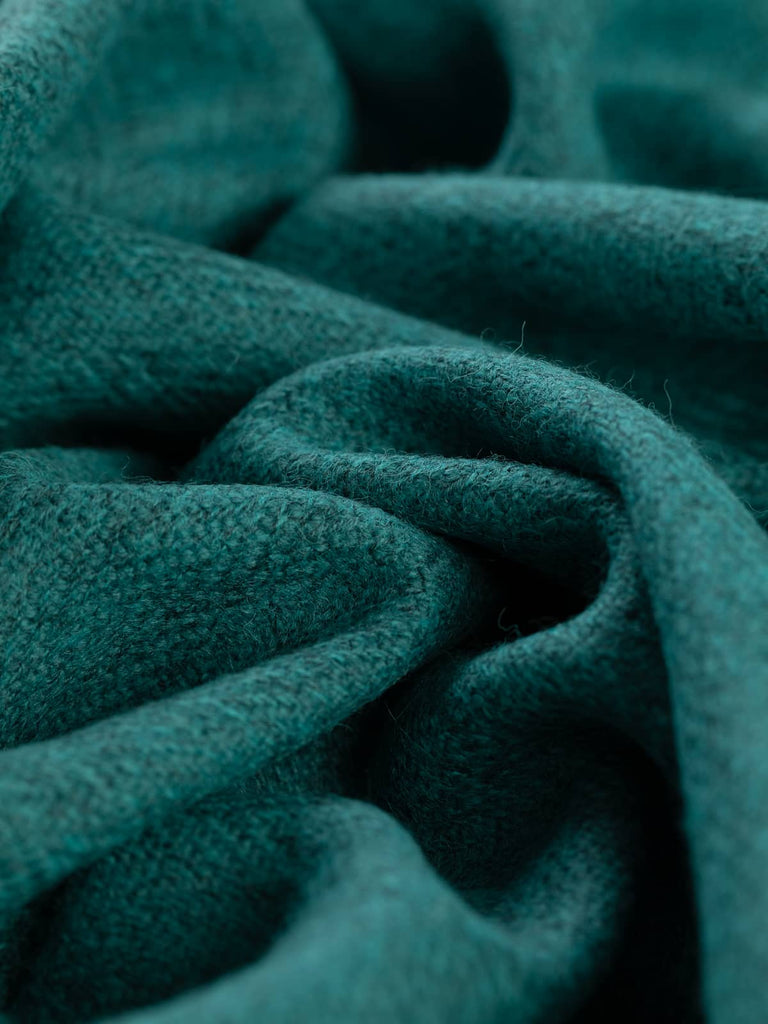 Twist of Tealstone Yorkshire Wool Herringbone Tweed, 100% wool, 400gsm, showing deep teal-blue and marled grey yarns blended in a softly textured chevron weave inspired by coastal cliffs and polished gemstones