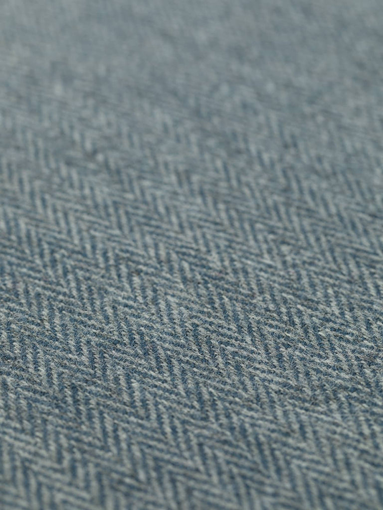 Angled flat view of Twilight Quarry wool tweed, 160cm wide, showing the rich, shadowy interplay of grey and slate-blue tones within a soft, brushed herringbone weave.