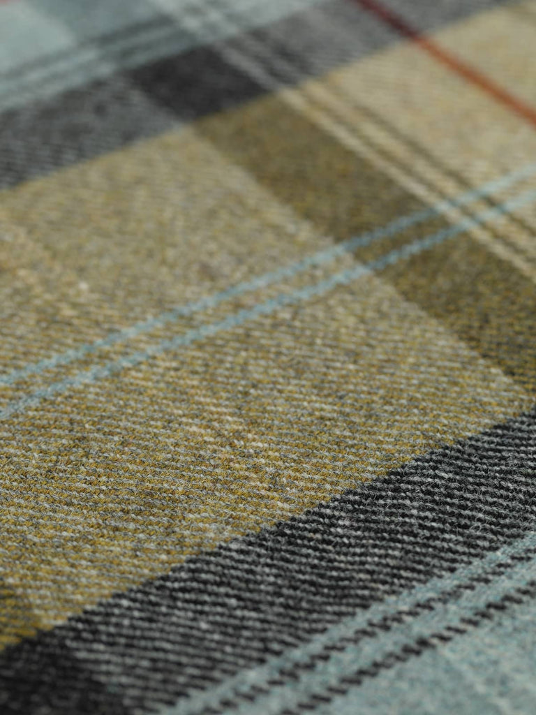 Angled flat view of Kelpline Tweed Heritage Plaid, medium-weight wool tweed with 25.5cm x 27.5cm repeat, highlighting coastal-inspired palette of golden olive, aqua-grey, and sea coal black checks