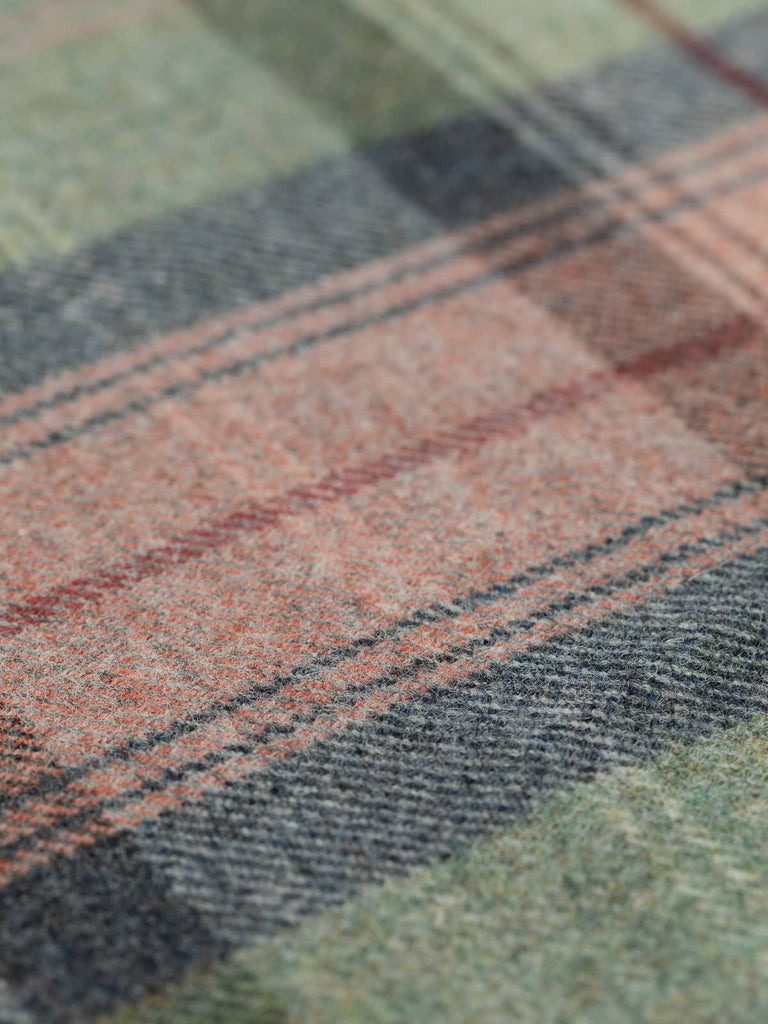 Angled flat view of Heathland Blush Heritage Plaid, medium-weight wool tweed with 25.5cm x 27.5cm repeat, highlighting autumn-inspired palette of misty greens, navy melange, coral blush, and subtle white frost lines