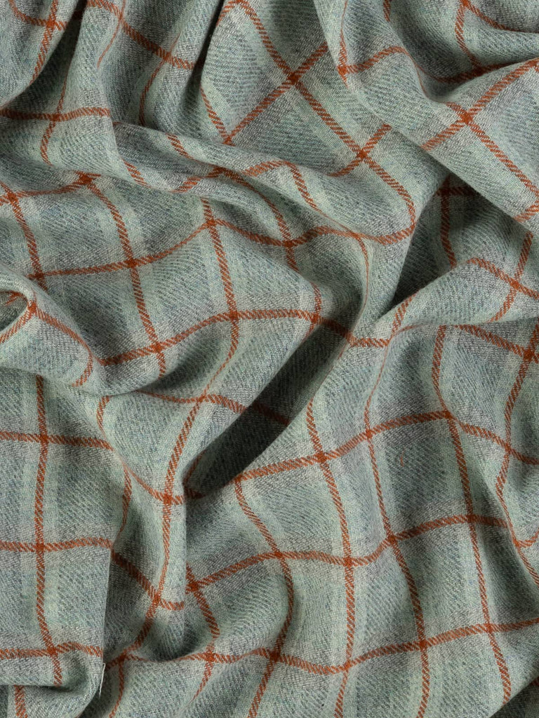 Overhead flat shot of First Light Yorkshire woollen windowpane check, capturing delicate marled grey background, large sky-blue squares, and Cedarwood overcheck across rugged wool texture