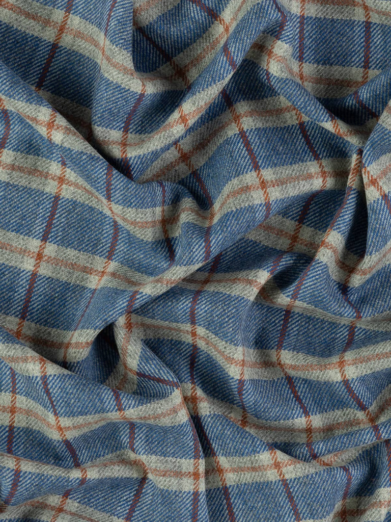 Overhead flat shot of Stargazer View Yorkshire woollen windowpane check, capturing frosted grey base, celestial blue squares, and warm red-hued Cedarwood overcheck across textured wool surface