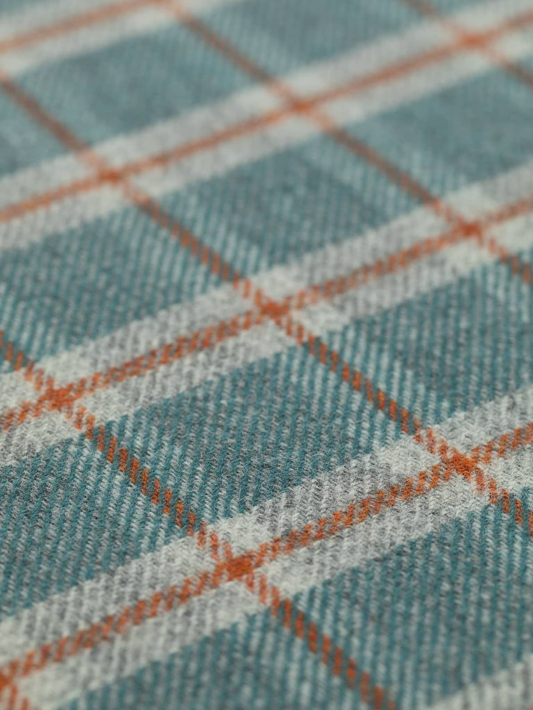 Angled flat view of Sea View Heritage Check, medium-weight wool with 5cm x 6cm repeat, highlighting North Sea-inspired palette of teal and green water tones, frosted grey, and structured Cedarwood windowpane accents