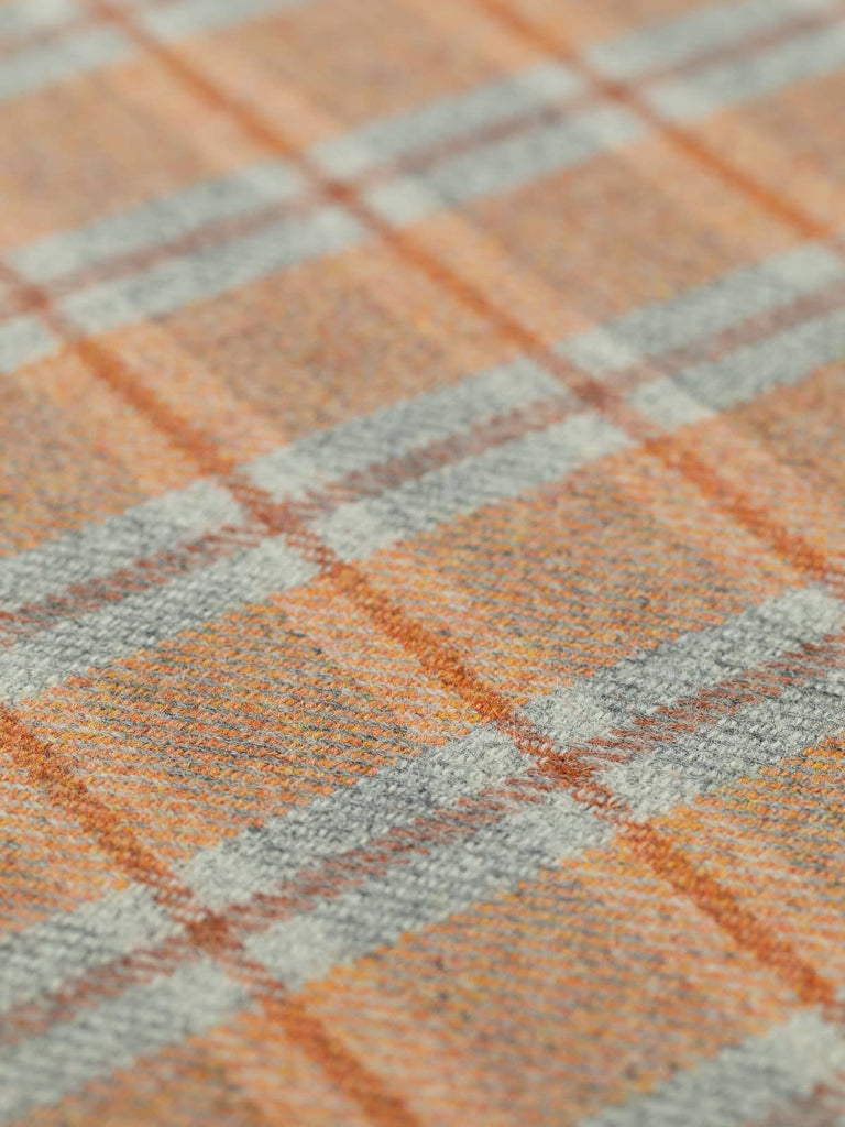 Angled flat view of Ember View Heritage Check, medium-weight wool with 5cm x 6cm repeat, highlighting vibrant orange tones, frosted grey background, and structured Cedarwood windowpane accents