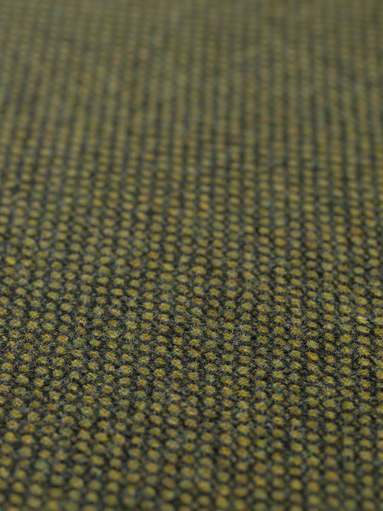 Angled flat view of Greenewt Birdseye Tweed, 150cm wide, revealing the detailed birdseye weave with multi-tonal greens and natural depth reminiscent of woodland ponds and shaded moss.