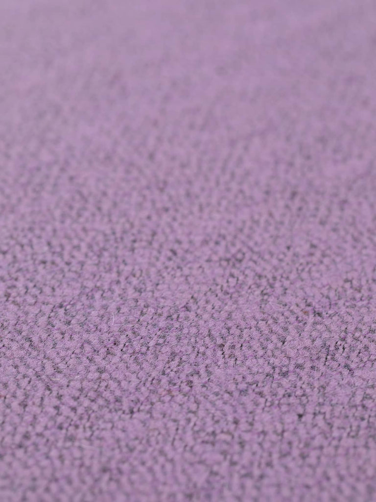 Angled flat view of Crystal Amethyst Bouclé Herringbone Tweed, 150cm wide, highlighting its marled lilac-amethyst hues, fine charcoal flecks, and soft, brushed wool surface with gentle texture.