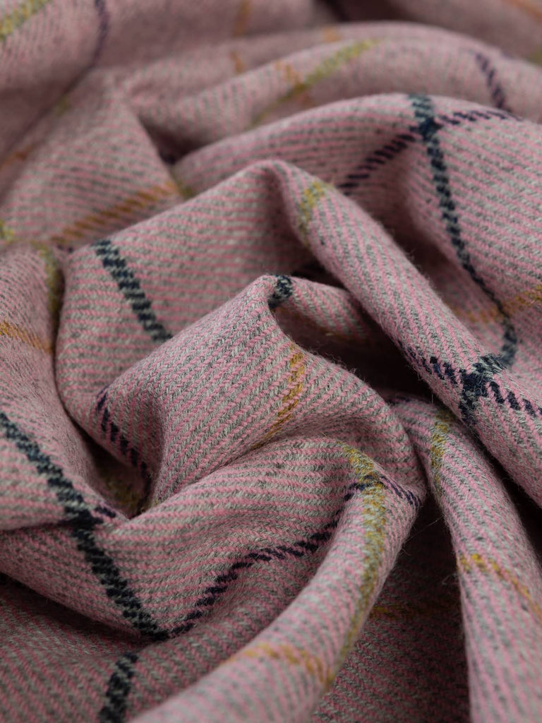 Angled twist shot of Dusk Bloom Yorkshire Tweed, showing pink and grey melange base with navy and golden-green windowpane lines revealed through softly twisted folds.