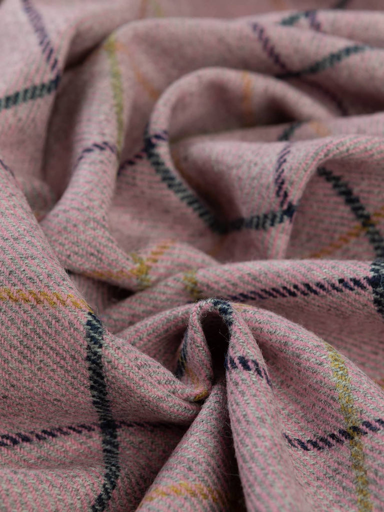 Aerial twist shot of Dusk Bloom fabric, capturing twisted depth from above and highlighting the romantic pink melange, grey marl undertones, and contrasting navy and green windowpanes.