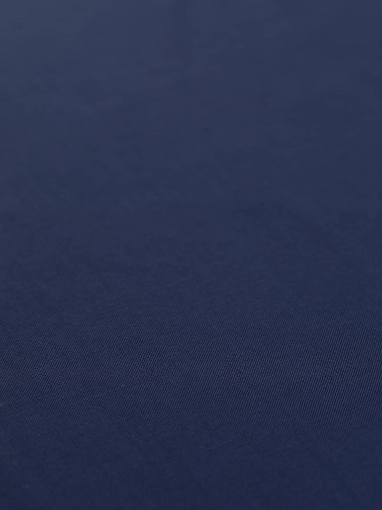 Spread-out view of the Indigo Dream fabric, highlighting its deep jewel-tone indigo color and fine twill texture. This light/medium-weight wool fabric drapes beautifully, making it ideal for tailored suits, dresses, and outerwear. Perfect for both autumn/winter and spring wardrobe pieces.