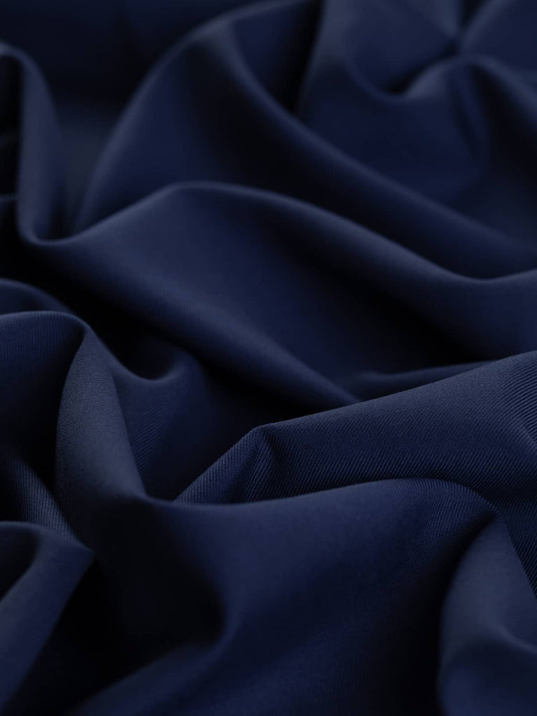 Close-up of Indigo Dream fabric showing its elegant twill weave and semi-matte finish. The stunning indigo hue is complemented by a substantial drape, suitable for tailored blazers, wide-legged trousers, and utility styles like boiler suits. A versatile, high-quality wool fabric for stylish, modern pieces.