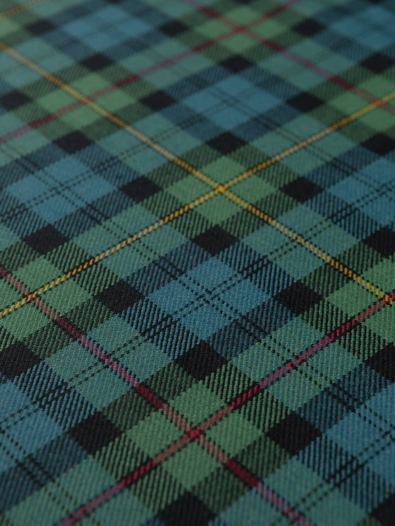Flat lay of MacEwan Muted Tartan Wool Twill displaying even checks of spruce green-blue, black, gold, and Highland red with a soft twill texture.