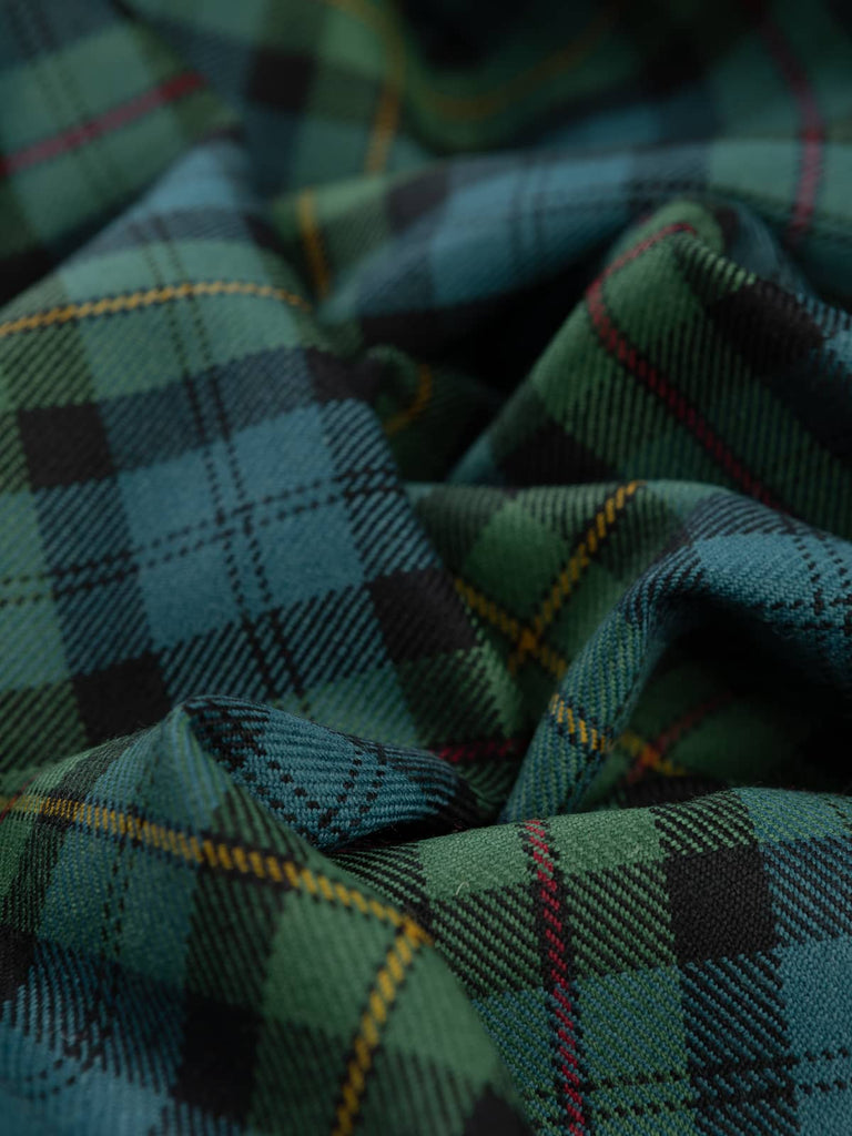 Soft twist of MacEwan Muted Tartan fabric showing its medium-weight wool texture and traditional twill weave in muted teal, gold, and red tones.