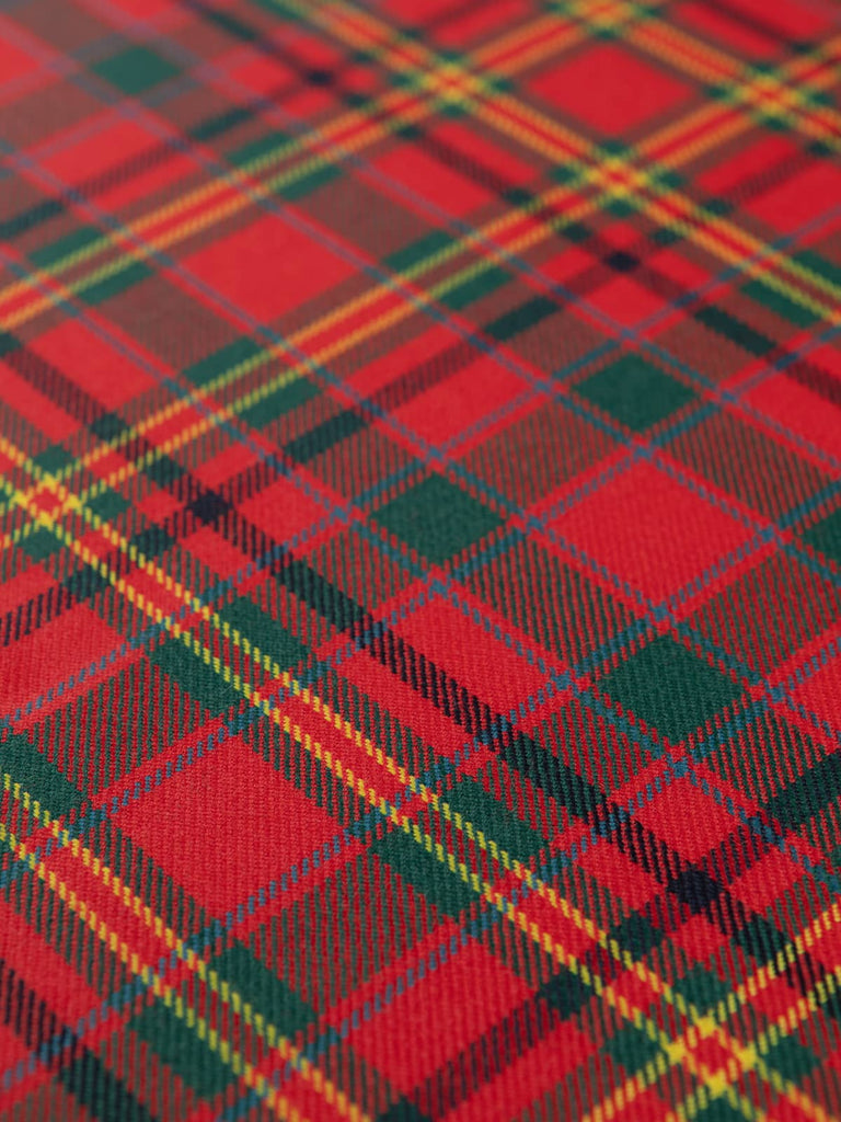 Flat overhead view of MacAlister Modern Tartan fabric showing balanced red, green, navy, and gold checks in traditional twill weave with smooth wool finish.