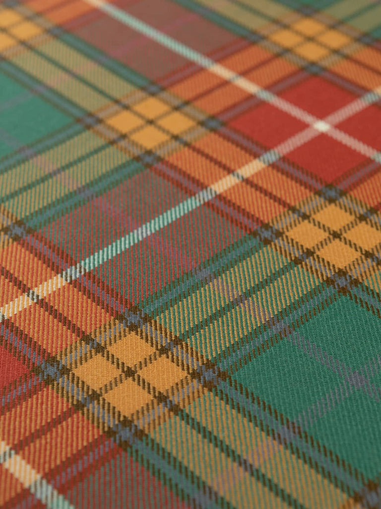 Flat lay of Antique Buchanan Tartan fabric revealing balanced muted tartan pattern in gold, rust, pine, and blue hues with a crisp white overcheck.