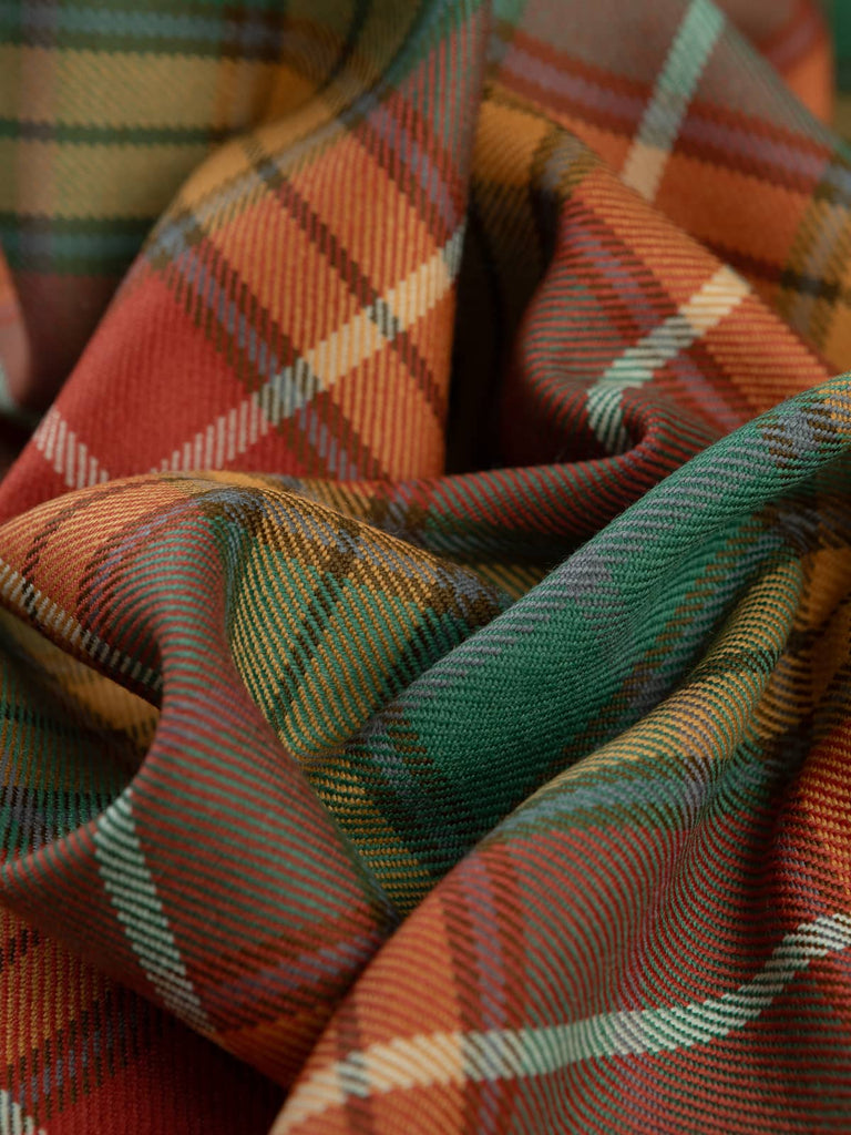 Twisted shot of Antique Buchanan Tartan highlighting its soft wool twill texture and warm autumnal tones of russet, olive, and spruce with pale blue accents.