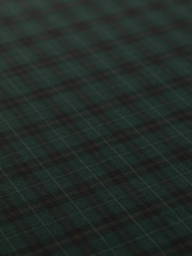 Spread-out view of the Bosco di Notte Check fabric, highlighting the intricate windowpane pattern with alternating black, dark green, and hazel brown tones. The light/medium-weight wool fabric has a sleek, classic twill weave, perfect for semi-tailored garments and sophisticated outerwear.