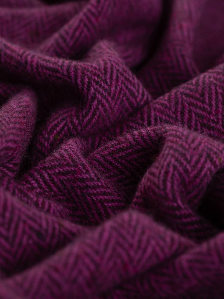 The close-up view of the Berry Beautiful fabric reveals a rich tapestry of berry hues, showcasing the deep plum and magenta yarns intertwined, along with subtle flecks of cranberry red and purple, creating a delightful, textured appearance.