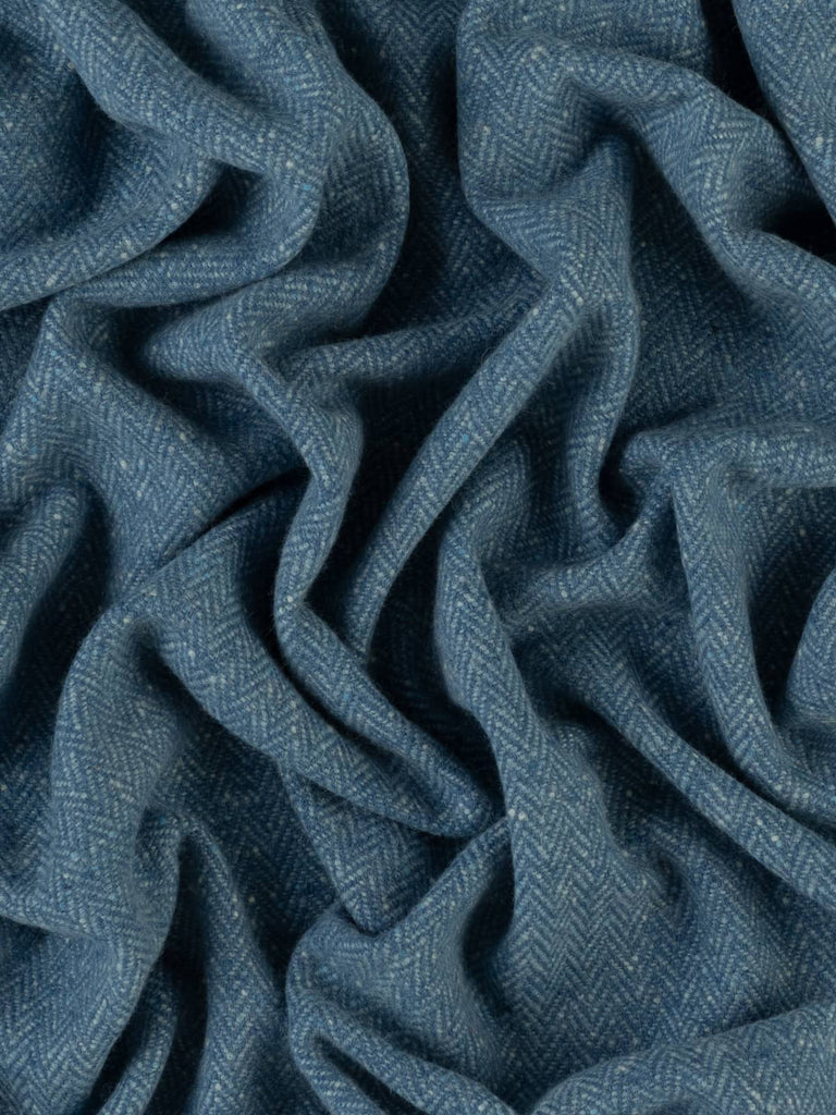 An aerial perspective reveals the serene beauty of the Glenevin Blue fabric, where the harmonious blend of deep blue melange yarns and lighter accents creates a tranquil, flowing effect reminiscent of cascading water, perfect for stylish, comforting designs.