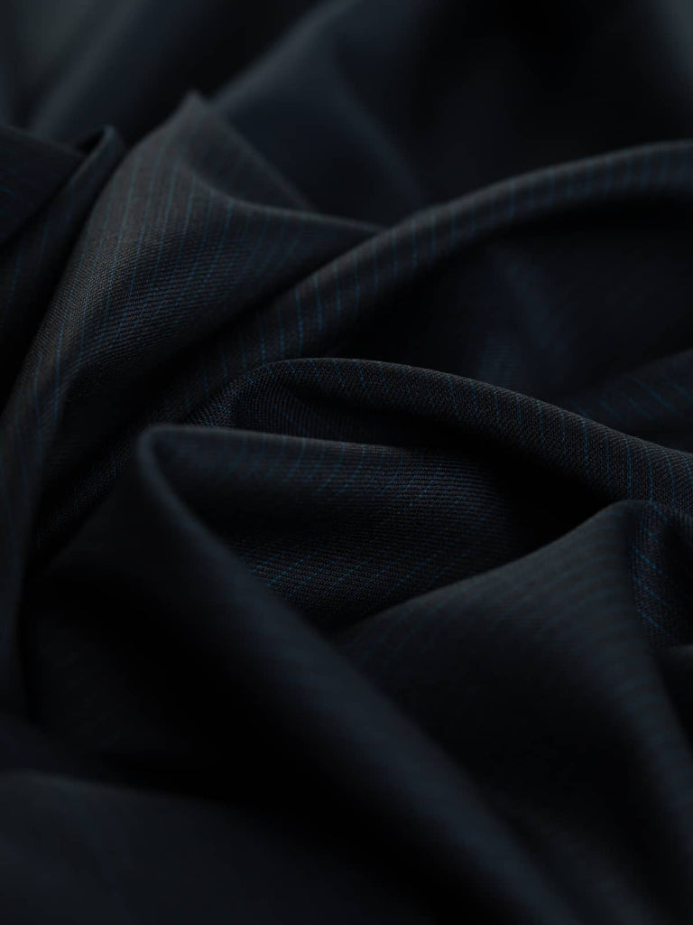 The Navy & Sapphire pinstripe fabric twisted to reveal the smooth texture and subtle sheen of the worsted wool.