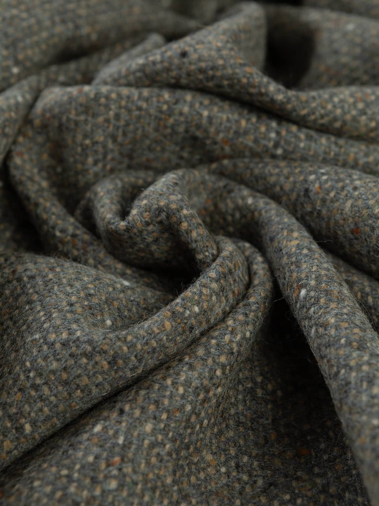Twist of Pebble Beach Tweed showing natural grey and brown herringbone weave with Donegal neps and a softly brushed lambswool texture.