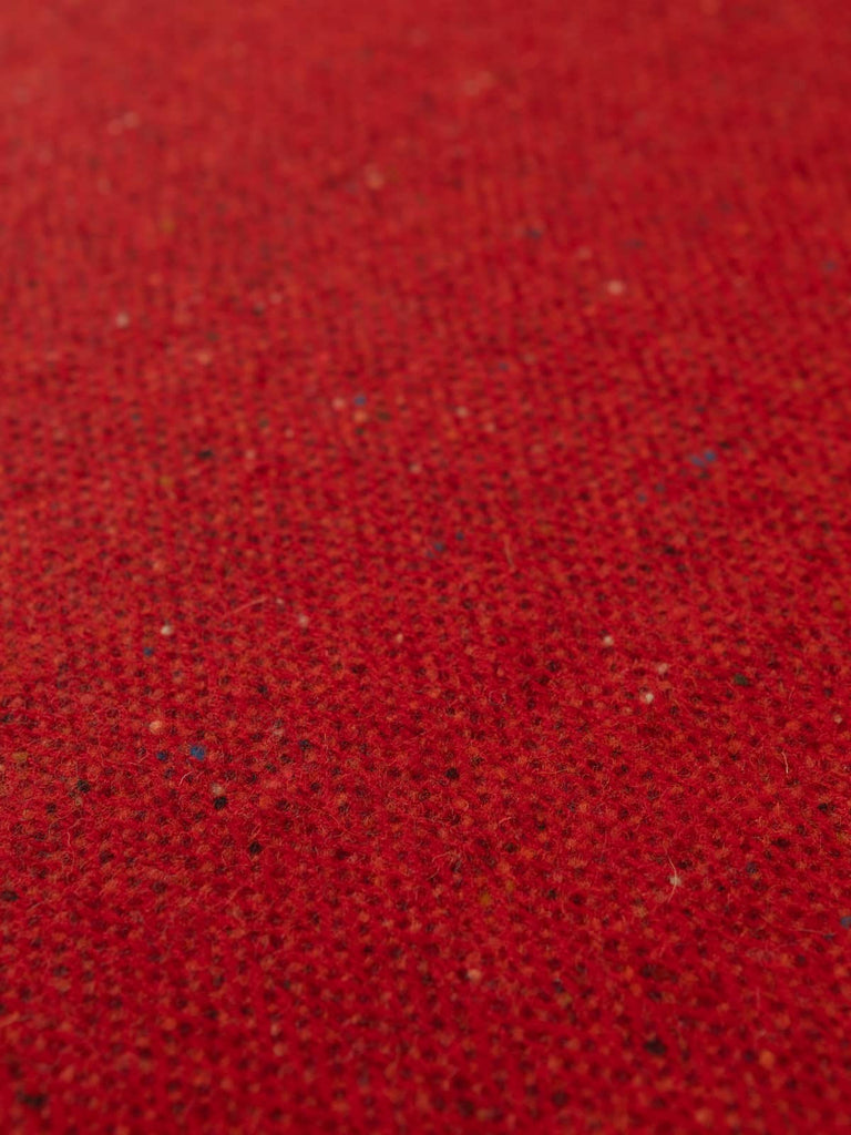 Flat overhead image of Capsicum Red Donegal Herringbone fabric, 162cm wide, displaying red chevrons with multicoloured Donegal flecks and soft textur