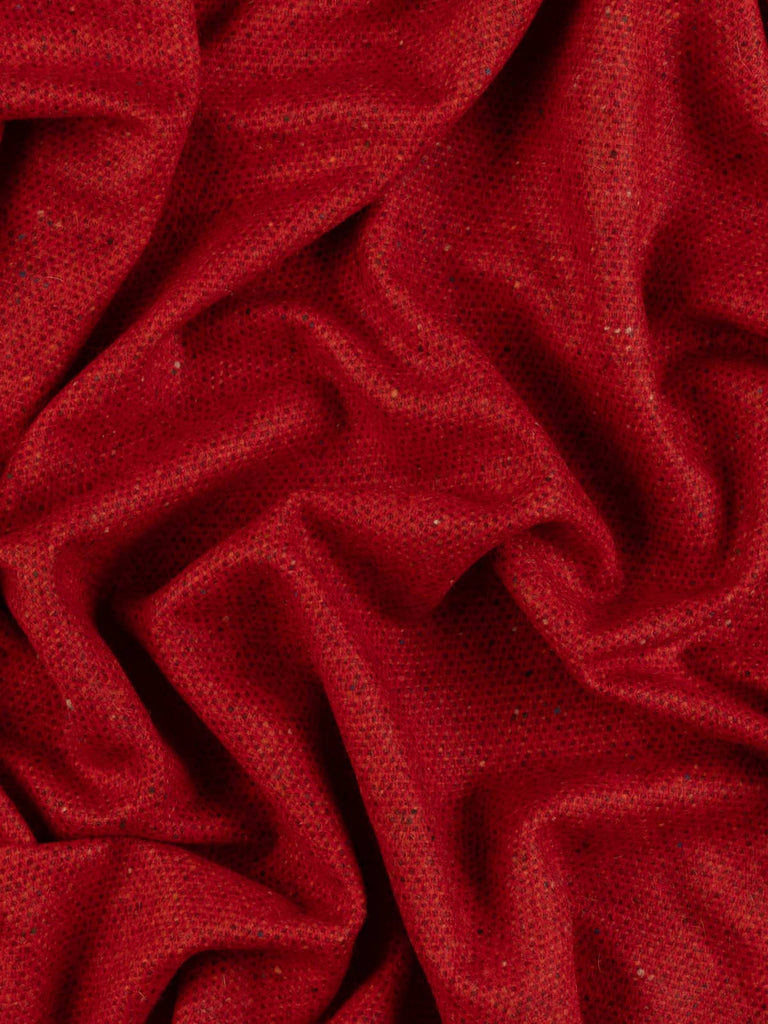 Twist of Capsicum Red Donegal Tweed showing brushed lambswool softness and a hot spice-inspired blend of chilli red, orange, and wine hues with neps.