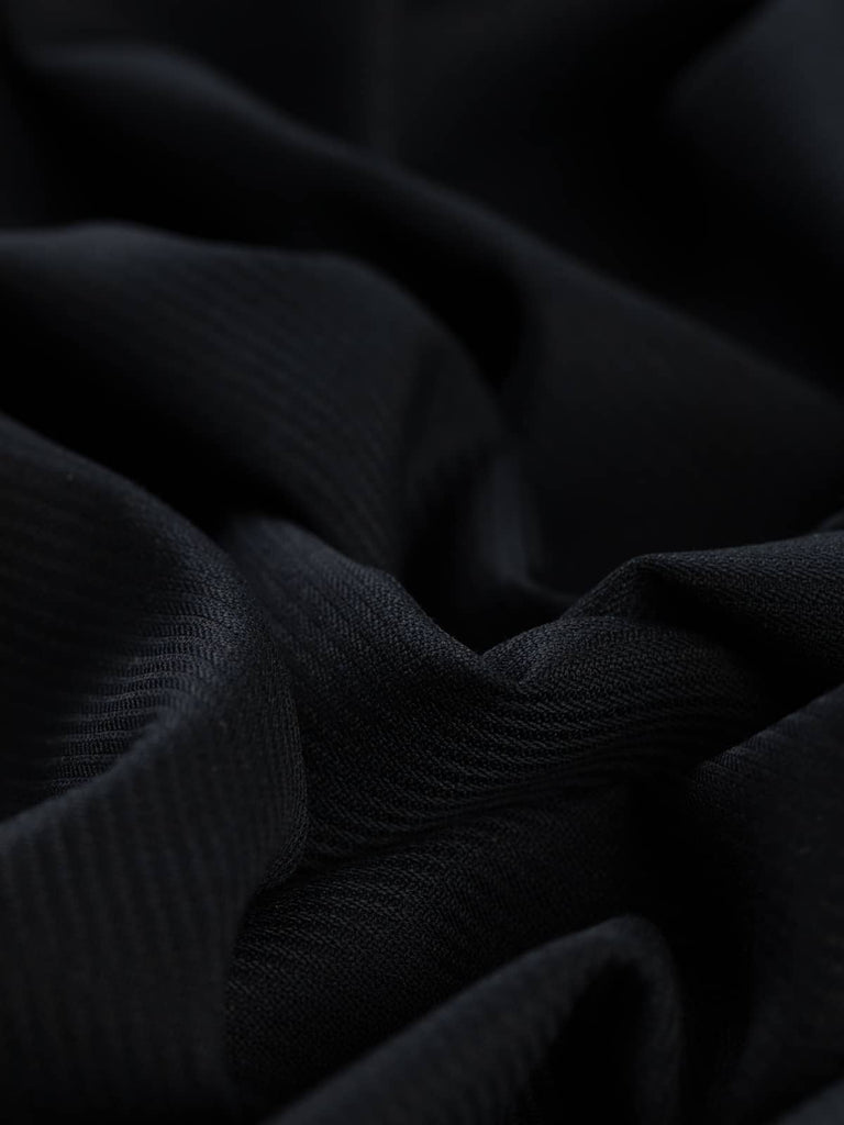 Angled twist shot of Navy Blue fabric, highlighting its soft drape, subtle two-tone effect from light on the twill, and smooth wool-poly finish