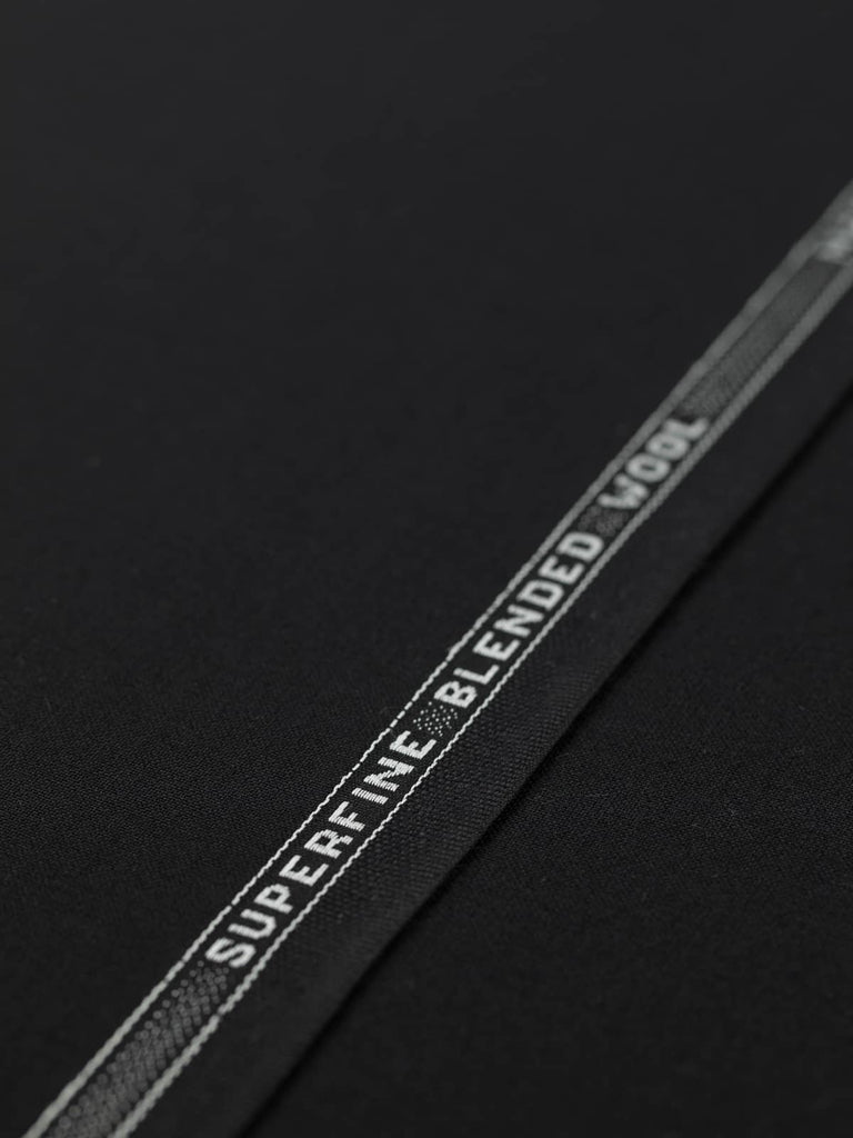 Flat, angled view of Coal Dust fabric, capturing its superfine worsted-like texture, all-over solid black colour, and smooth, polished surface.