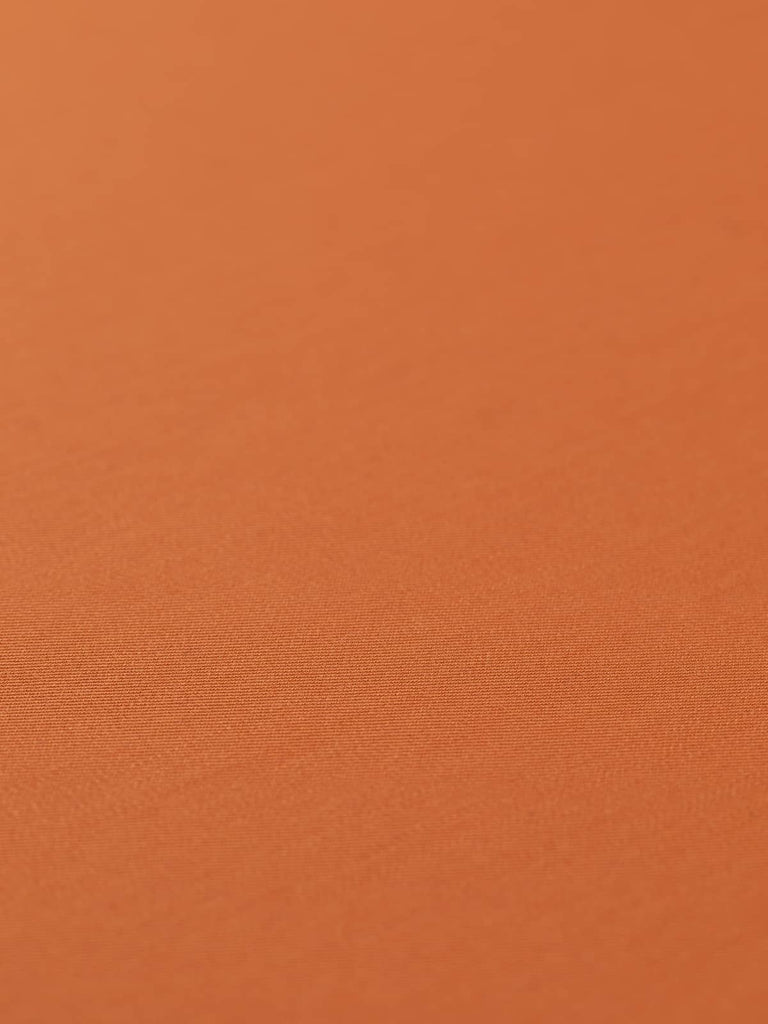 Flat, angled view of Rusty Orange fabric, capturing its deep rust-orange colour, lustrous finish, and crisp twill texture. Ideal for smart, structured pieces or bold accessories.