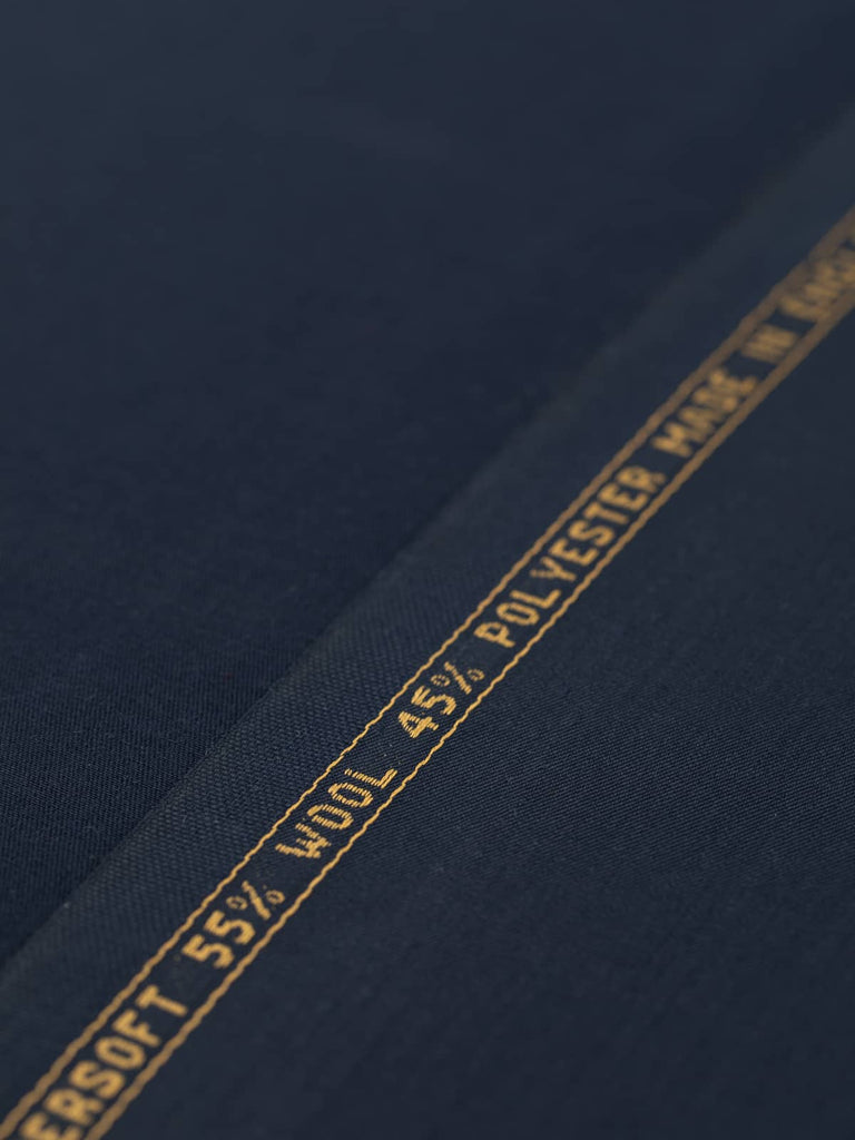 Angled flat lay of Peerless Navy fabric, displaying its even, deep navy tone and impeccable worsted-style finish. The fine wool and polyester blend offers a smooth, stable surface with an elegant, understated drape